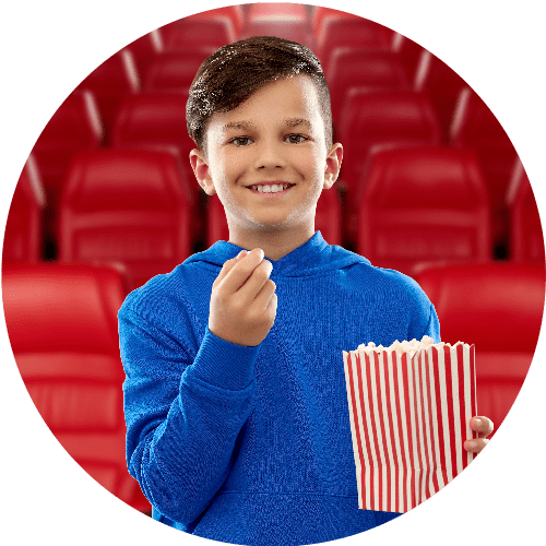 Boy eating popcorn in movie theater