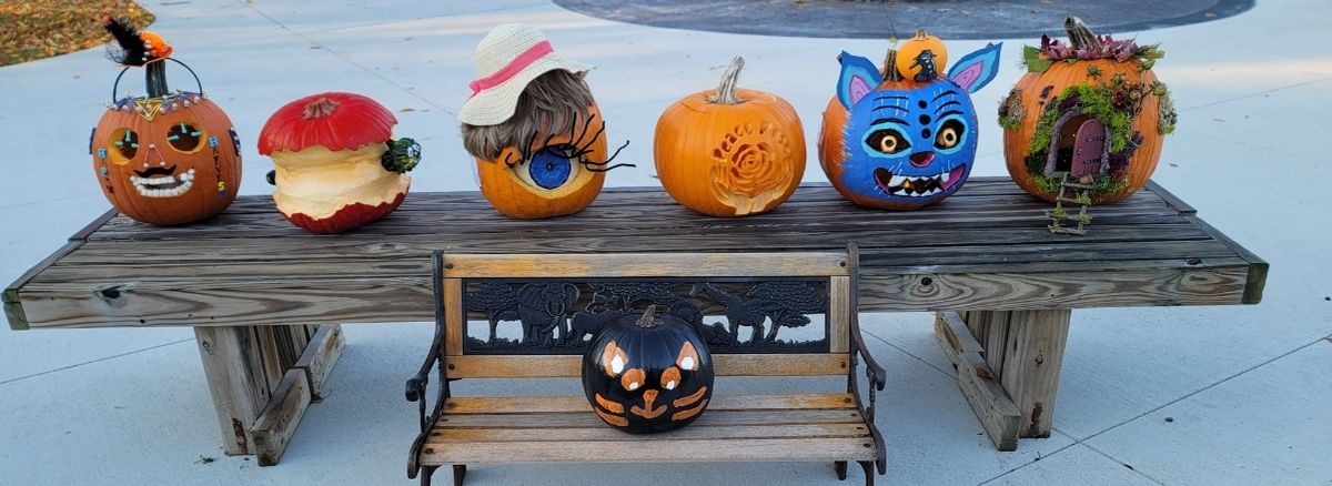 Decorated pumpkins sitting on benches