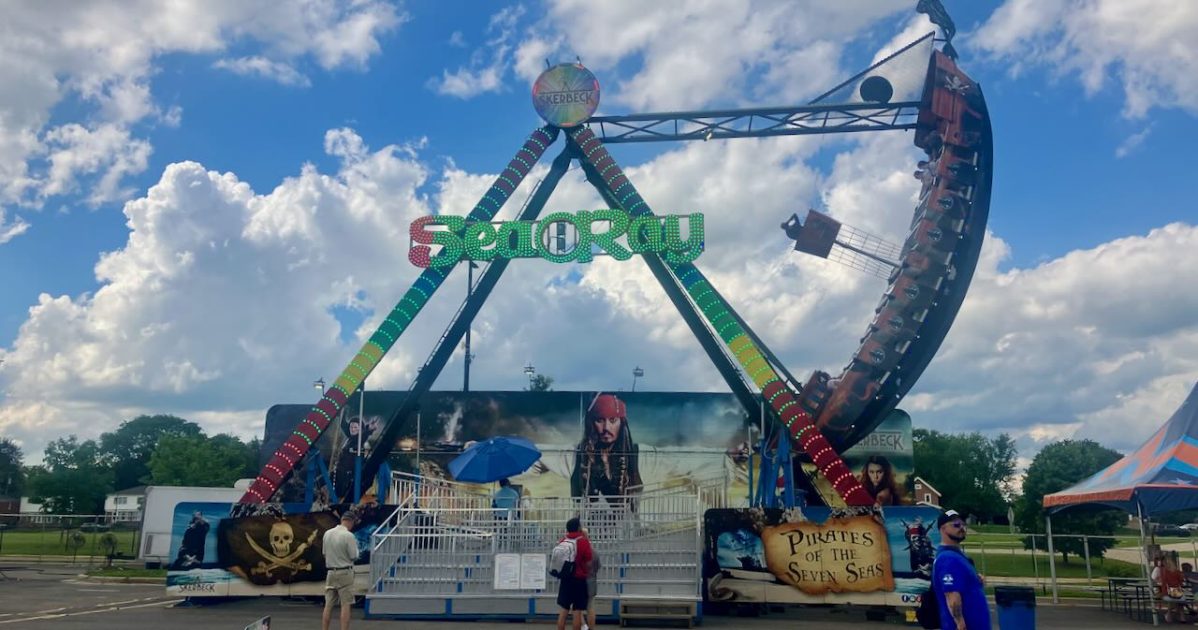 Ann Arbor Jaycees Carnival - Sea Ray Pirate Ship ride with backdrop that looks like Captain Jack from Pirates of the Caribbean althrough the ride is called Pirates of the Seven Seas