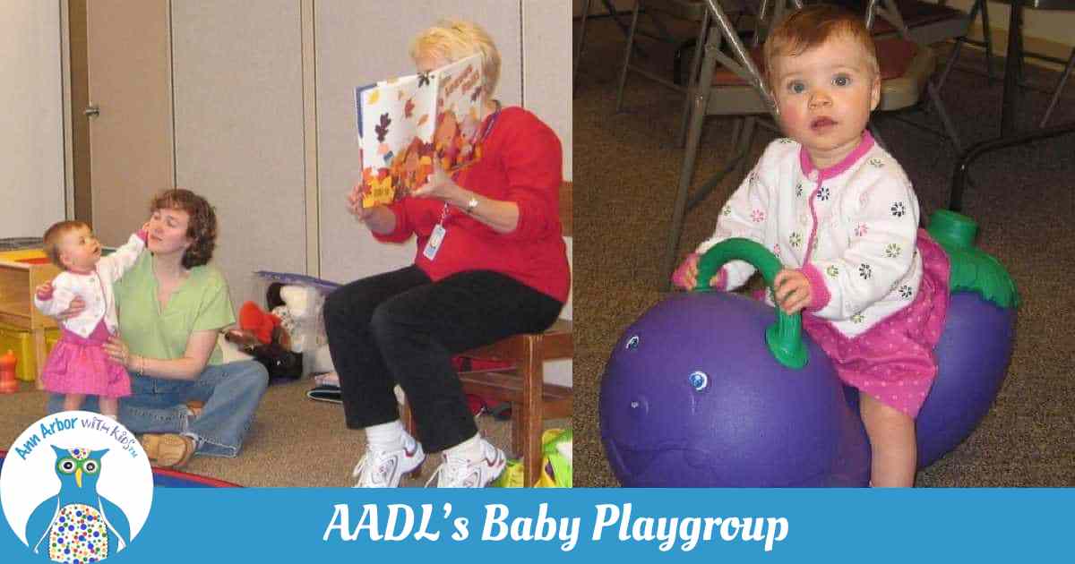 AADL Baby Playgroup - a baby stands supporte dby mom watching a storyteller holding a book. Same baby rides a purple eggplant rocker