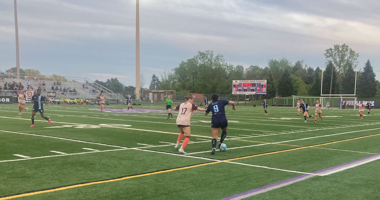 AFC Ann Arbor Women's Game - AFC Player #9 (in blue) kicks the ball against #17 in light orange