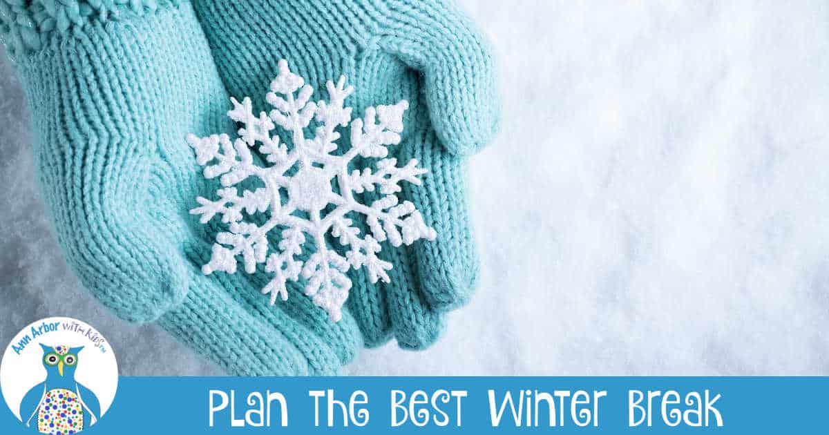 Plan the best Winter Break in Ann Arbor - teal gloves holding a snowflake on a bed of snow