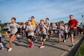 RunTough - kids and adults run in a pack along the road