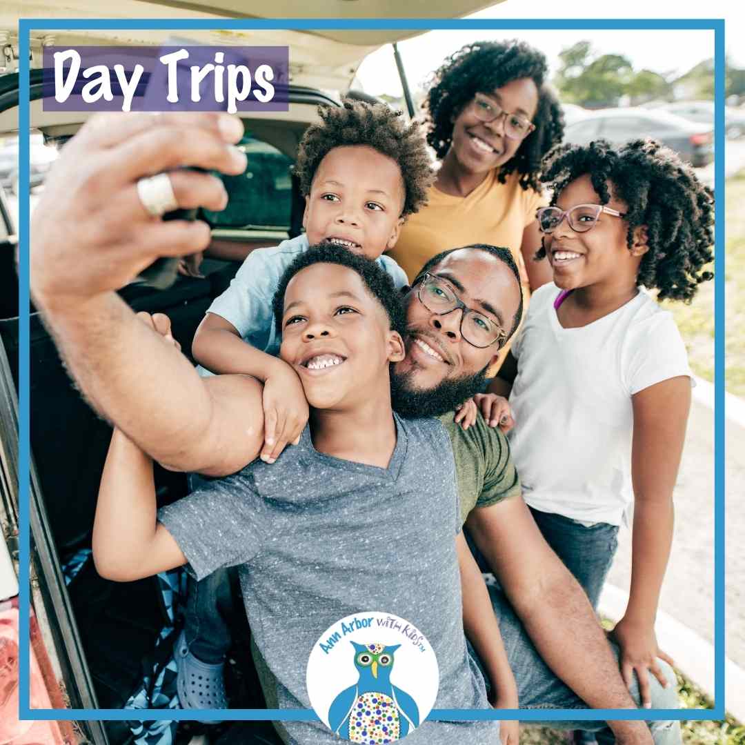 Day Trips from Ann Arbor - a family poses for Dad to take a selfie at the open rear liftgate of their vehicle.