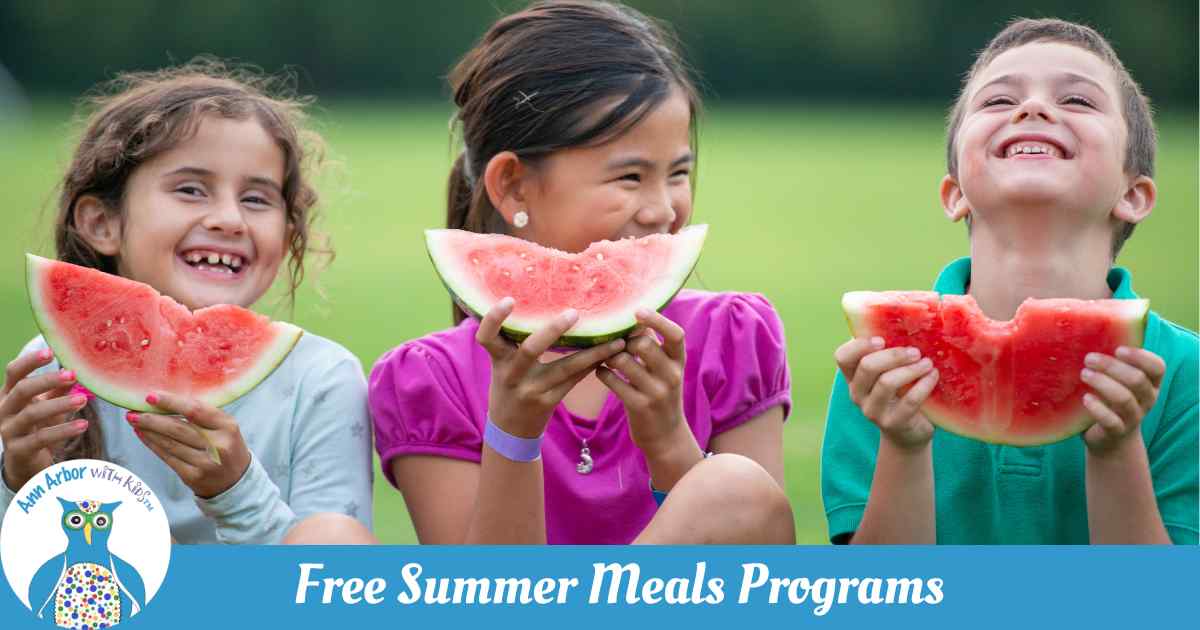 Free Summer Meals programs - 3 kids sit in a field eating large watermelon slices