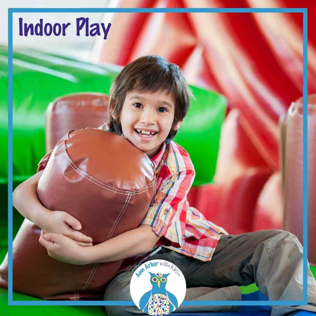 Indoor Play - a boy sits in an indoor play area with foam or inflated bumpers