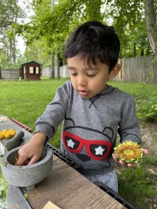 Manzanitas - a boy places flowers in a mortar.
