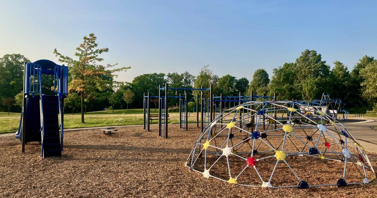 Marshview Meadows playground- older child play area with dome climber, and structure of climbers and various styles of monkey bars plus a stand alone double slide.