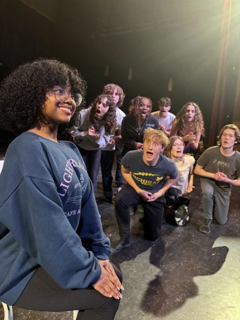 Teen actress as Roxie Hart sings "We Both Reached for the Gun" while members of ensemble look on with incredulous faces from Pioneer Theatre Guild's production of Chicago: Teen Edition