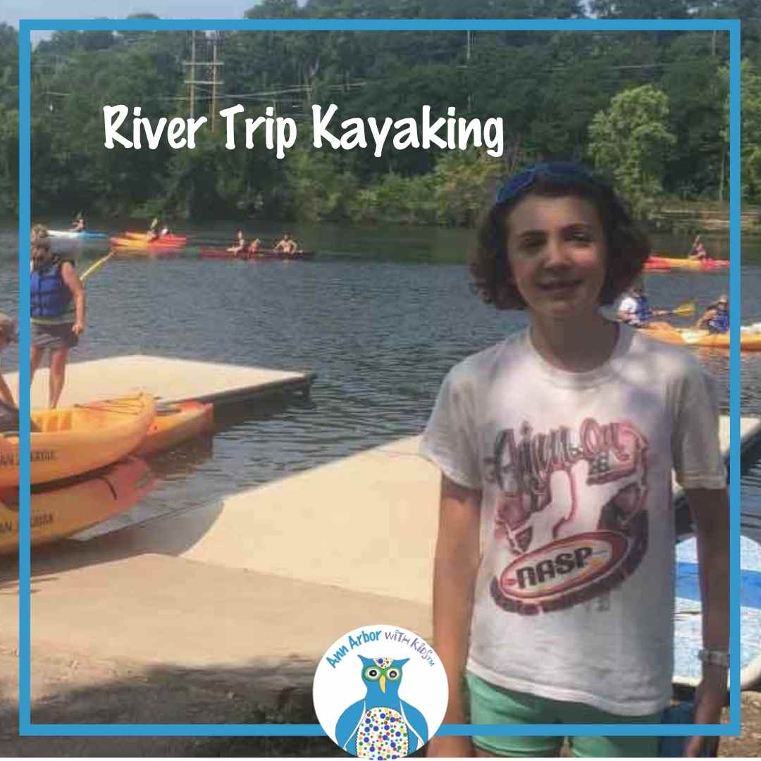 Ann Arbor River Trip Kayaking - Ready to Go - a tween stands on the dock in front of kayaks (she'll add the lifejacket before heading out)