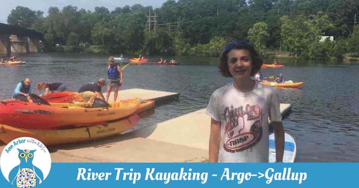 Ann Arbor River Trip Kayaking - Ready to Go - a tween stands on the dock in front of kayaks (she'll add the lifejacket before heading out)