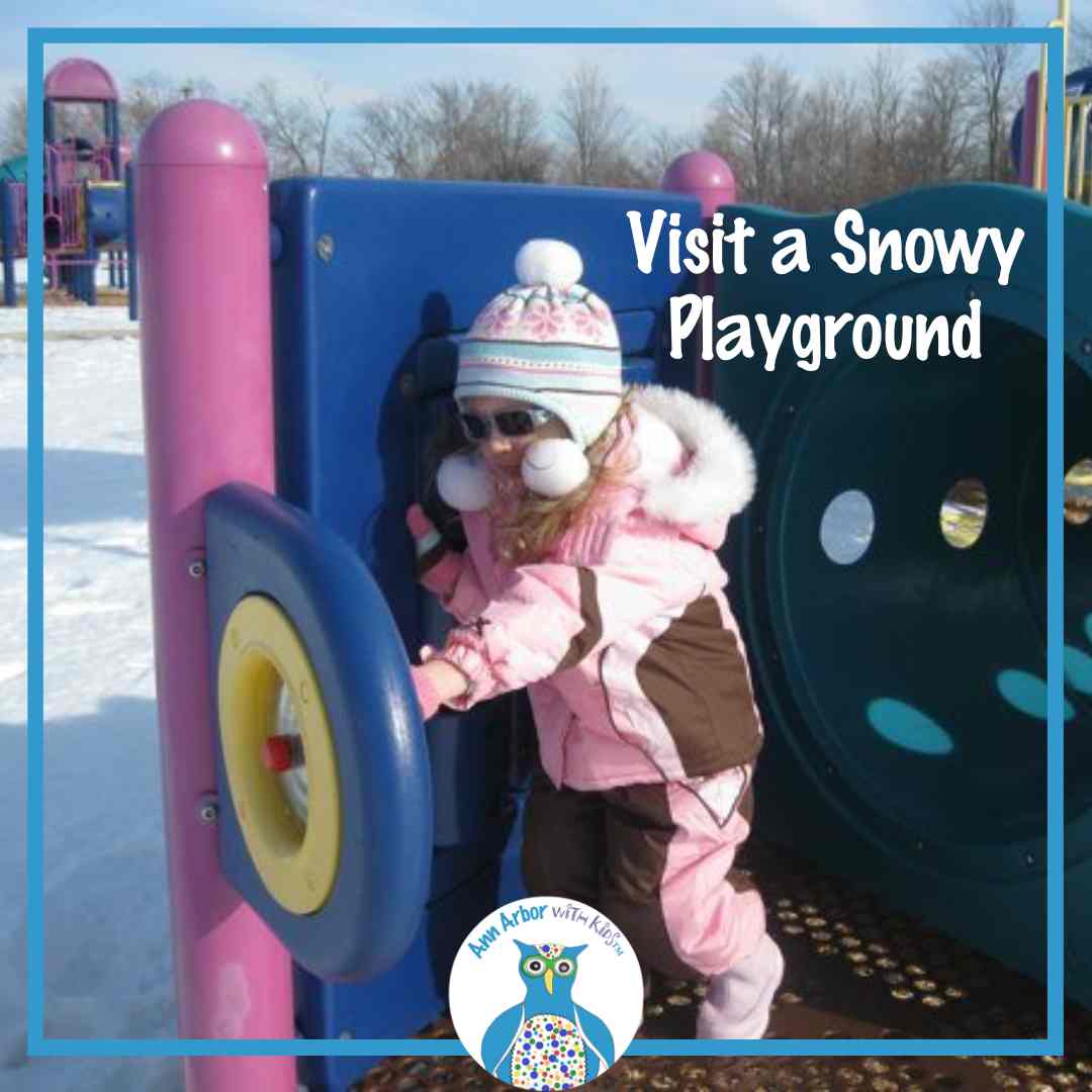 Visit a Snowy Playground - A preschooler bundled in a snow suit & hat plays on a playground with snow on the ground