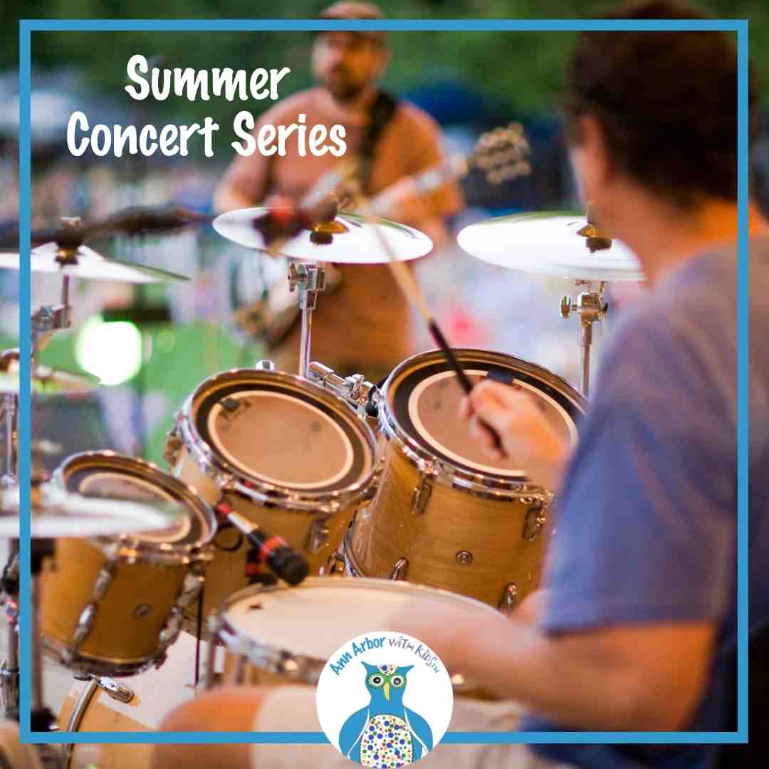 Summer Concert Series - a band plays on stage in a park - a drummer & guitarist