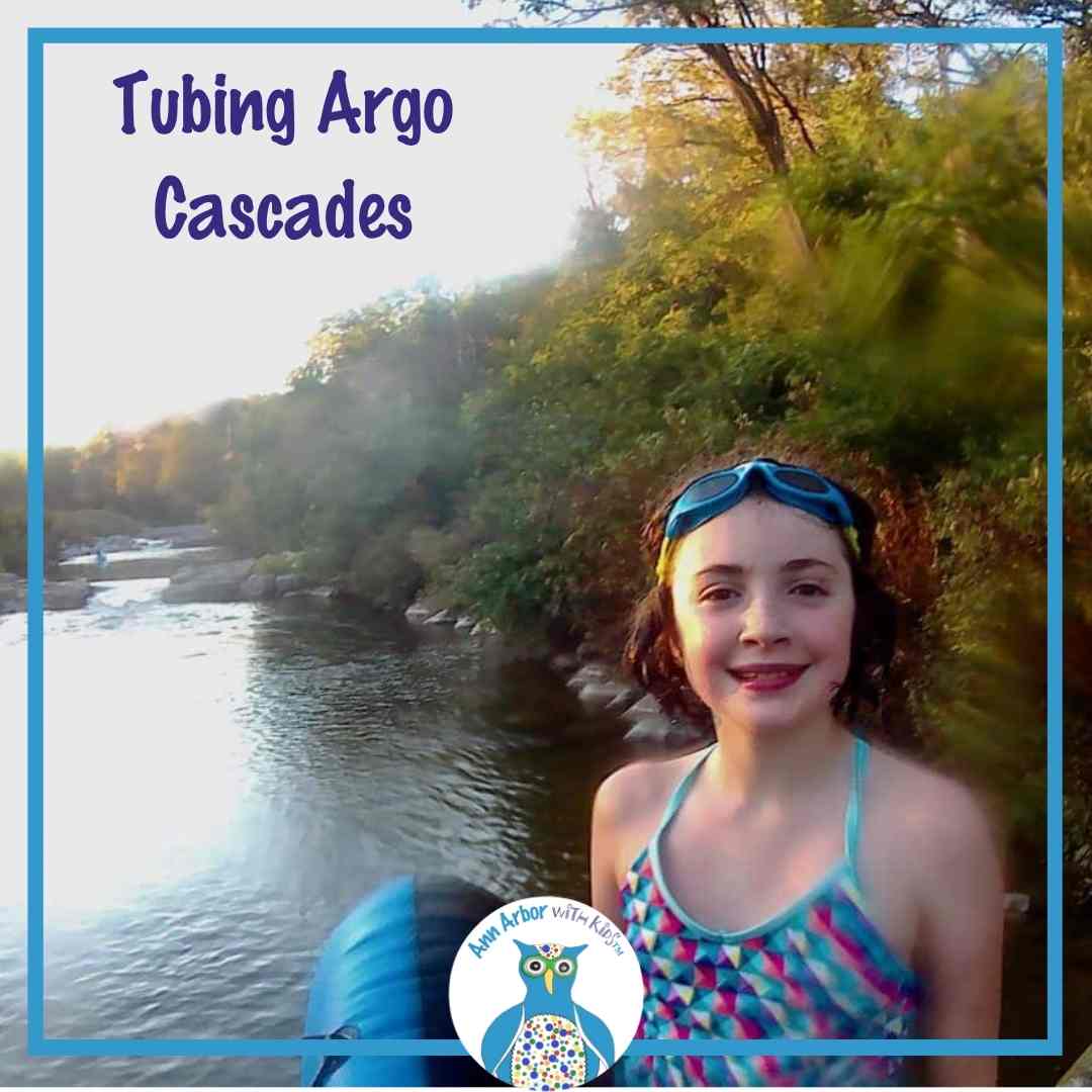 Tubing Argo Cascades - a tween holds a tube at the base of the Argo Cascades
