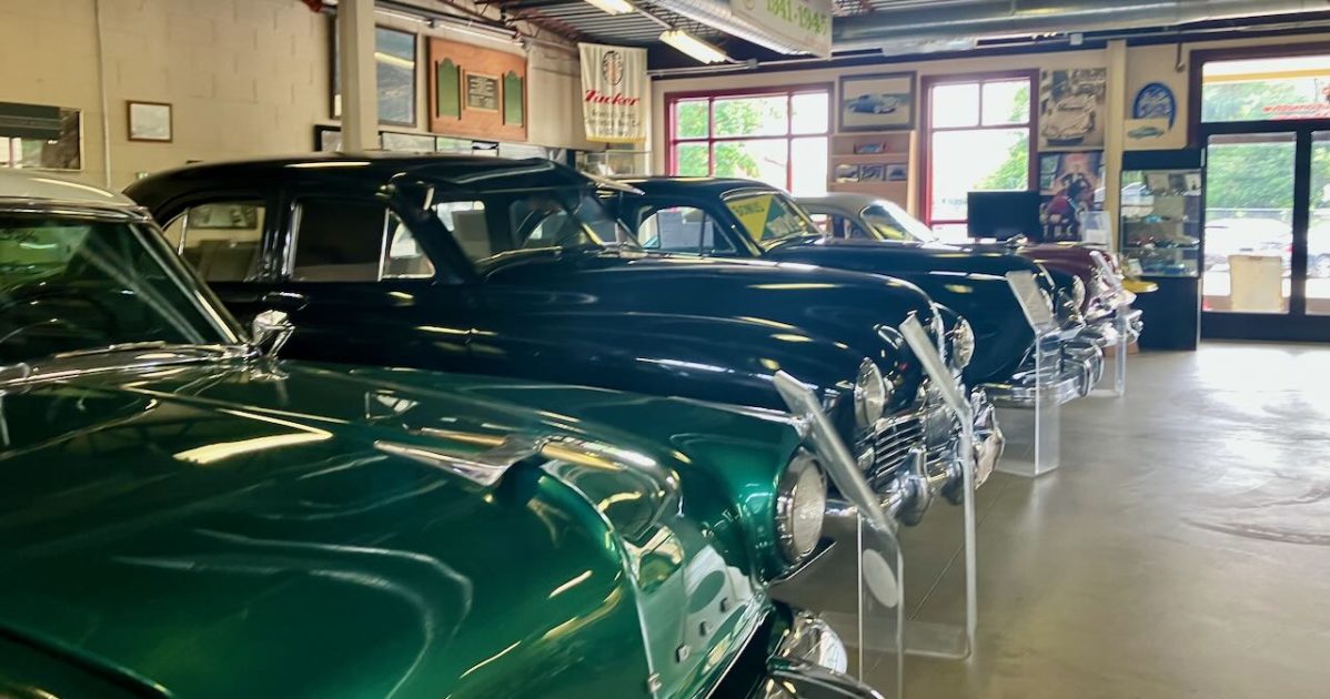 Ypsilanti Automotive Heritage Museum - row of Cars under a Tucker sign